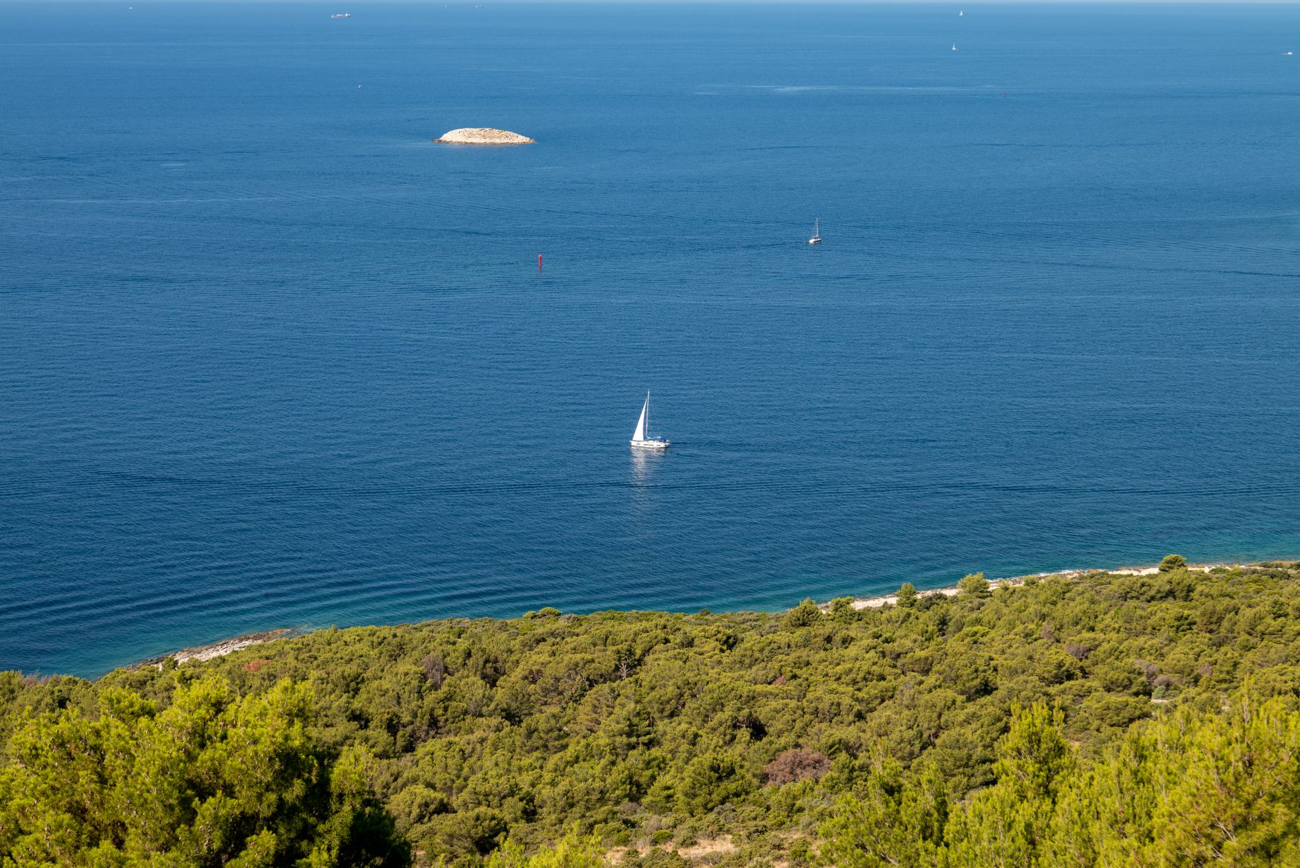 Eaux turquoise entre les îlots rocheux et dénudés du parc national des Kornati